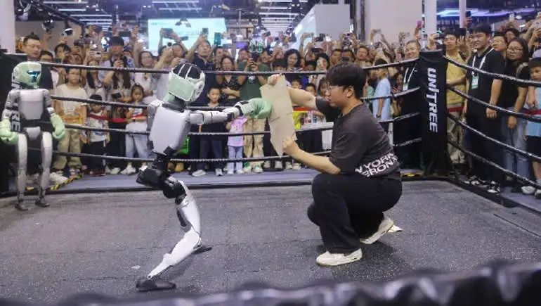 2025年7月27日，上海，宇树科技G1人形机器人闪耀世界人工智能大会擂台，戴上拳击手套和保护头套，在人类裁判监督下进行了格斗比赛表演赛，展现其文武双全：会春晚跳舞扭秧歌也会擂台武术真功夫。智慧敏捷反应归功于身体29个灵活关节和AI平衡算法。除热血运动外，机械拳王或学习了WWF摔角大数据，会挑衅对手、鼓动观众粉丝加油呐喊、夸张倒地的E人绝活，趣味拟人化的动作场面如综艺喜剧真人秀，节目效果十足。