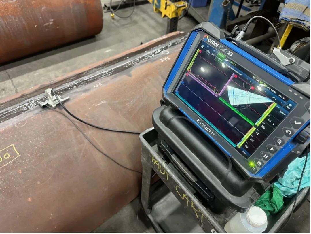 detector being used to inspect a weld in a metal pipe.