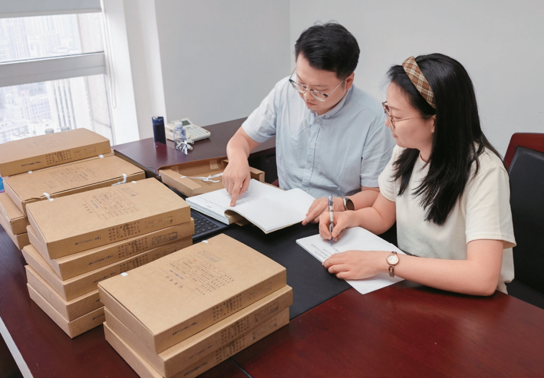 李鹏威（左）与同事查看会计凭证，核实疑点问题线索